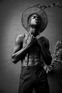 Portrait of young man standing against wall