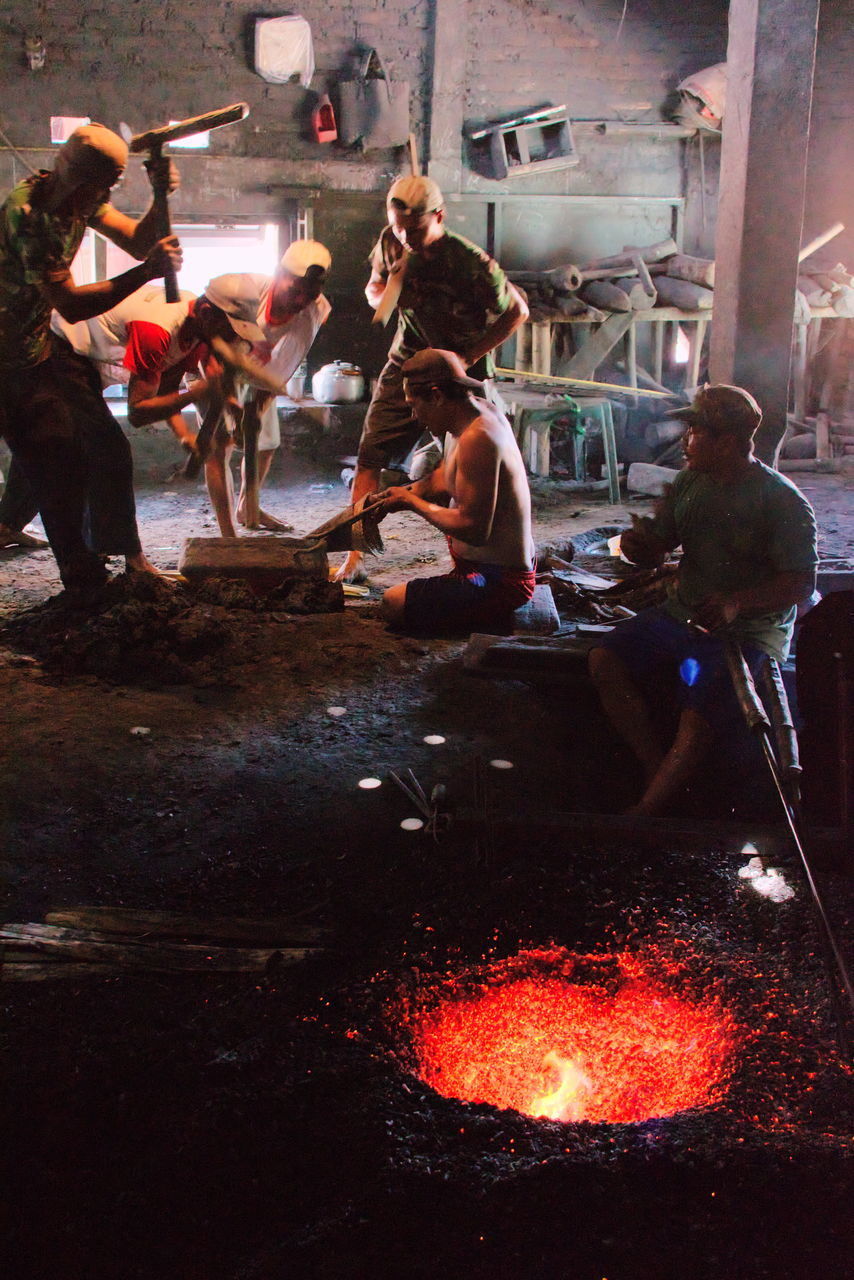 PEOPLE SITTING ON BONFIRE