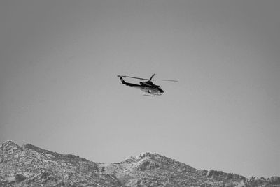 Low angle view of helicopter flying against clear sky