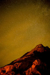 Low angle view of illuminated mountain against sky at night