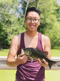Portrait of smiling young man holding fish