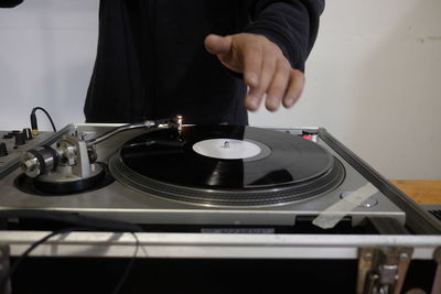 Midsection of man playing record