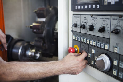 Cropped hand of man pressing push button on control panel