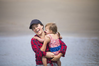 Full length of mother and daughter at beach