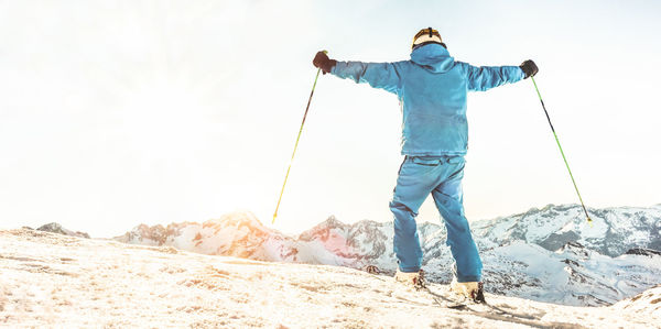 Rear view of man skiing on snow covered landscape