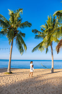 Rear view of woman walking at beach