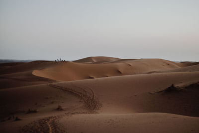 Sand dunes in desert against clear sky