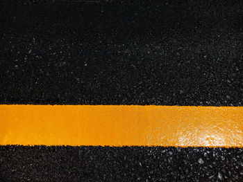 High angle view of yellow lines on road at night