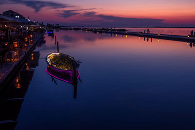 Boats moored on sea against sky during sunset