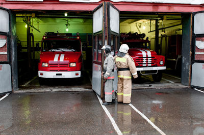 Firefighters respond to an emergency at work. they drive car out of the garage to save  lives