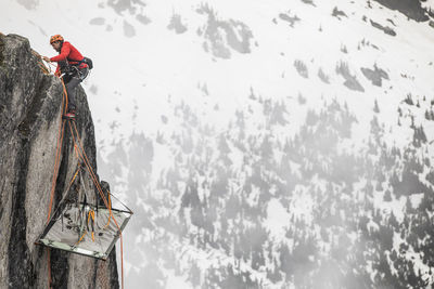 Rock climber uses prusik to ascend cliff above portaledge.