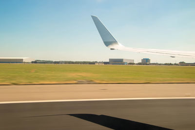 Airplane on airport runway against sky