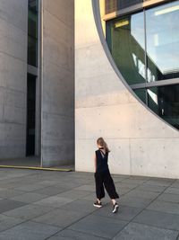 Full length of woman standing against brick wall