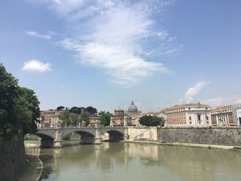 Bridge over river by vatican buildings against sky in rome