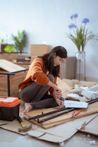 Woman fixing furniture at home