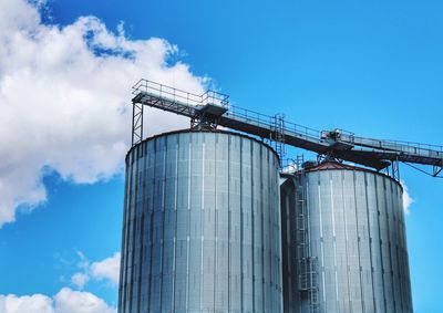 Low angle view of industry against blue sky