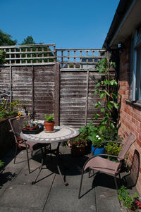 Potted plants on table by building against clear sky