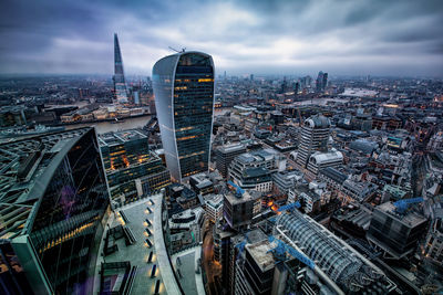 Aerial view of modern cityscape against cloudy sky