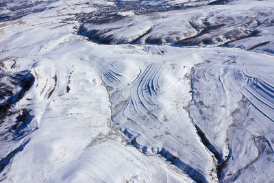 Aerial drone view of snow covered countryside terraces in the mountains