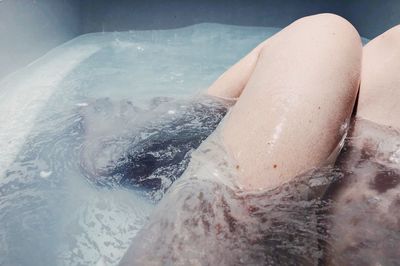 Low section of woman in bathtub