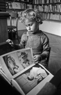 Boy looking at book in library