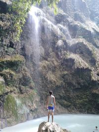 Rear view of woman looking at waterfall