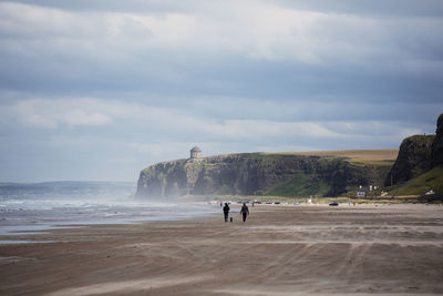 People at beach against sky