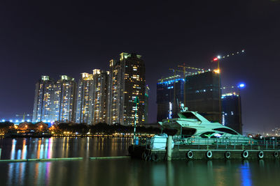 Boat moored on harbor with city buildings in background