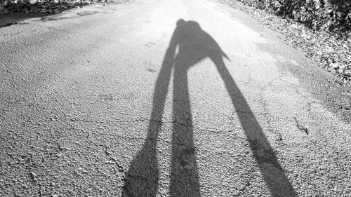 Shadow of person on road