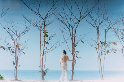 Full length of man standing on beach against sky