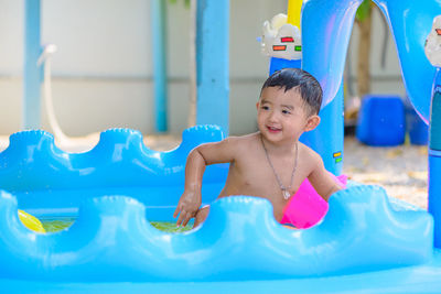 Happy cute boy playing in wading pool