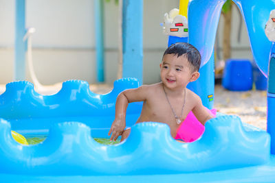Portrait of cute boy playing in swimming pool