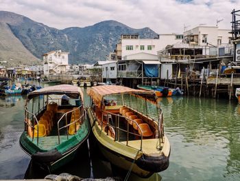 Boats moored in canal by buildings in city