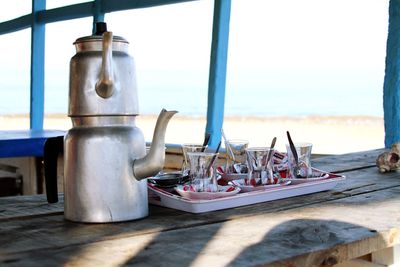 Close-up of kettles with glasses on table