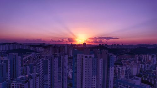 Aerial view of city against sky during sunset