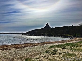 Scenic view of sea by mountains against sky