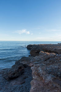 Scenic view of rocks on beach against sky