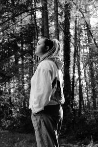 Rear view of woman standing in forest