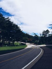 Empty road against cloudy sky