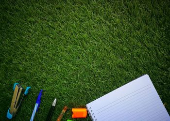 Directly above shot of office supplies on grassy field