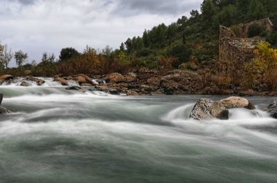 Scenic view of waterfall against sky