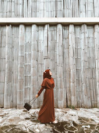 Rear view of woman standing on wood