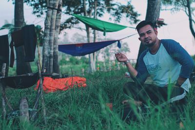 Young man holding umbrella on field
