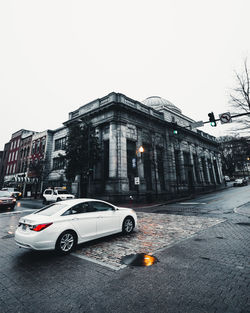 Cars on road against sky in city