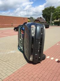 Cars on road against cloudy sky