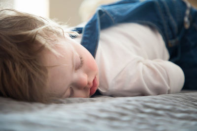 Close-up of cute baby sleeping in bed