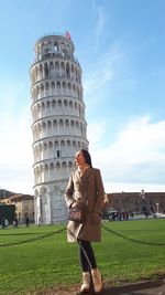 Full length of woman standing on grass against sky