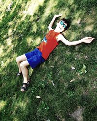 High angle view of woman lying on grassy field