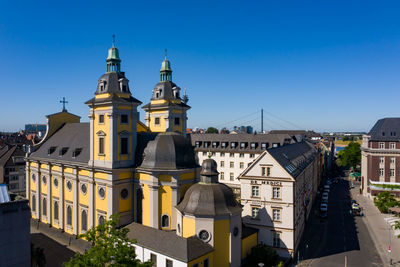 Buildings in city against clear blue sky