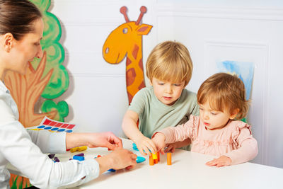 High angle view of siblings playing on table